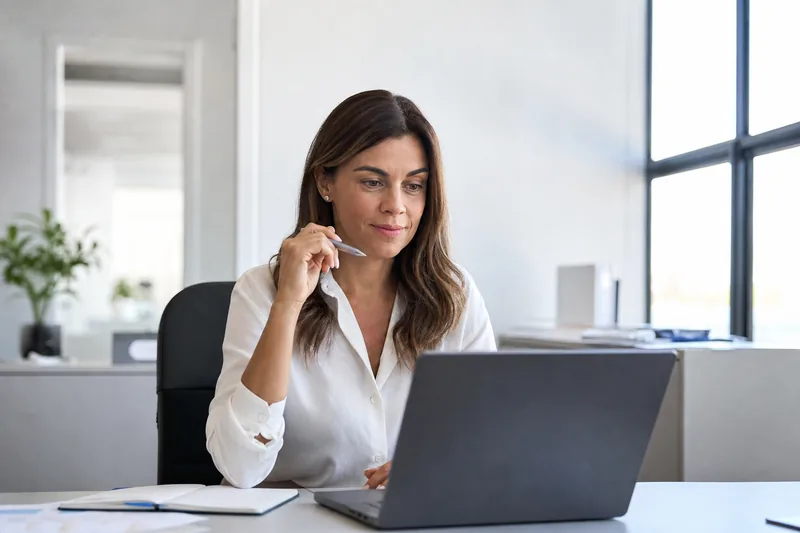Hiring manager comparing candidate scores on a laptop